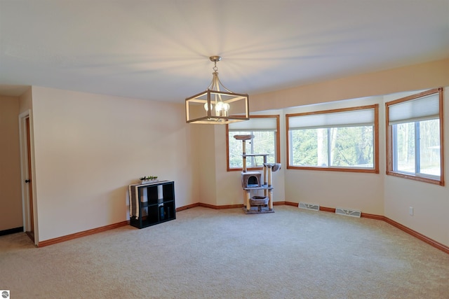 empty room featuring carpet floors and an inviting chandelier