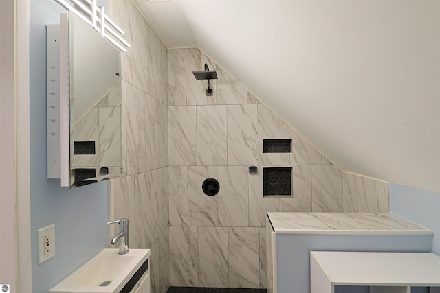 bathroom with a tile shower and sink