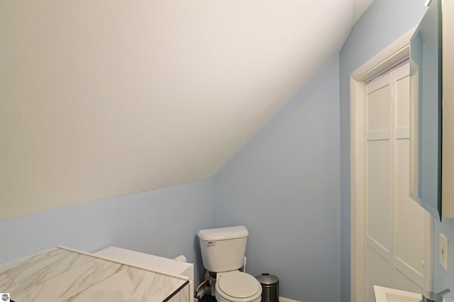 bathroom with lofted ceiling and toilet