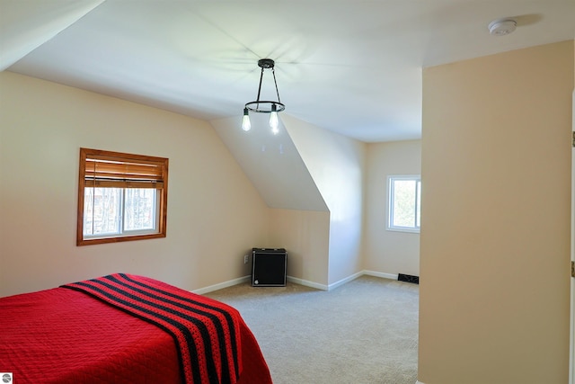 bedroom featuring lofted ceiling, light carpet, and multiple windows