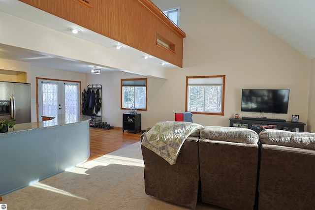 living room featuring french doors, high vaulted ceiling, and light hardwood / wood-style flooring