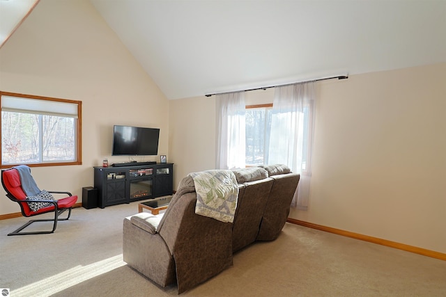 carpeted living room with a fireplace and high vaulted ceiling