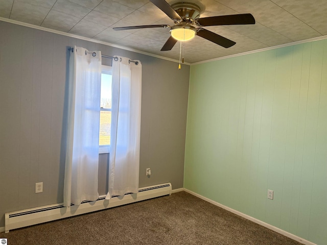 carpeted spare room with ceiling fan, wood walls, crown molding, and baseboard heating