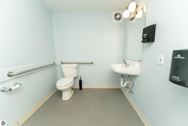 bathroom with concrete floors and toilet