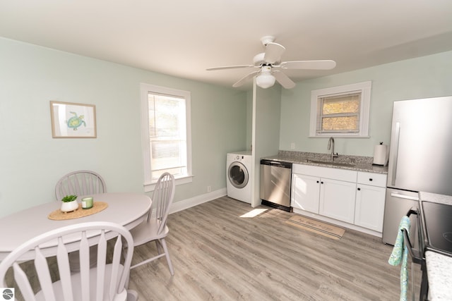 laundry area with washer / dryer, light hardwood / wood-style floors, ceiling fan, and sink