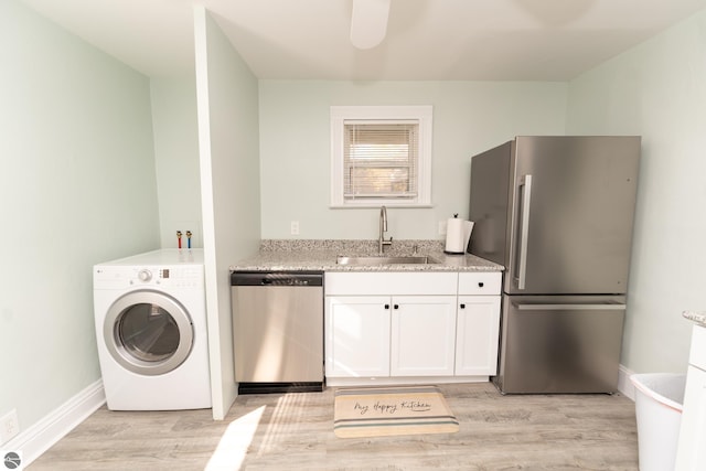 washroom with washer / clothes dryer, sink, and light hardwood / wood-style floors