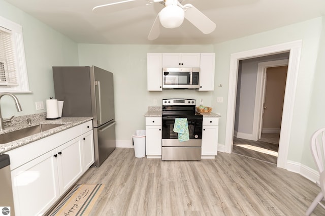 kitchen featuring white cabinets, sink, ceiling fan, light stone countertops, and appliances with stainless steel finishes