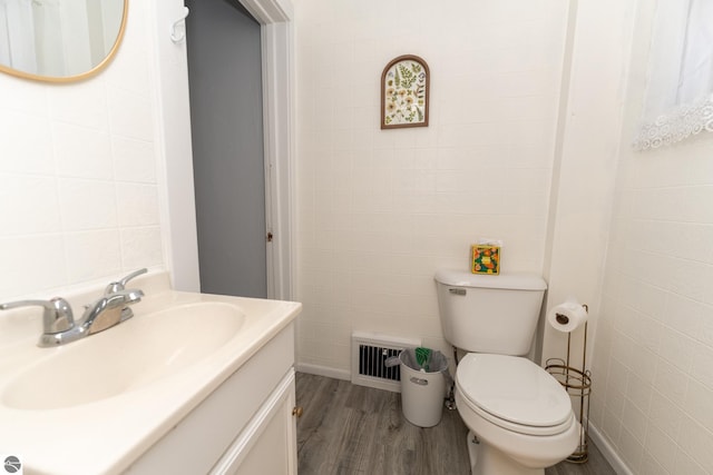 bathroom with toilet, vanity, and hardwood / wood-style flooring