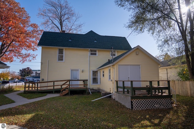 rear view of house with a lawn and a deck