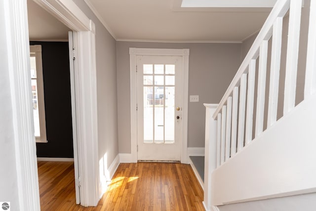 entrance foyer with a healthy amount of sunlight, light hardwood / wood-style floors, and ornamental molding