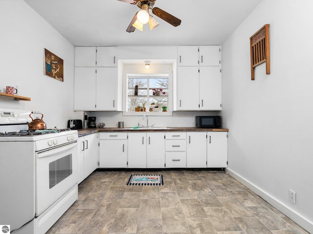 kitchen with ceiling fan, sink, white cabinets, and white range with gas stovetop