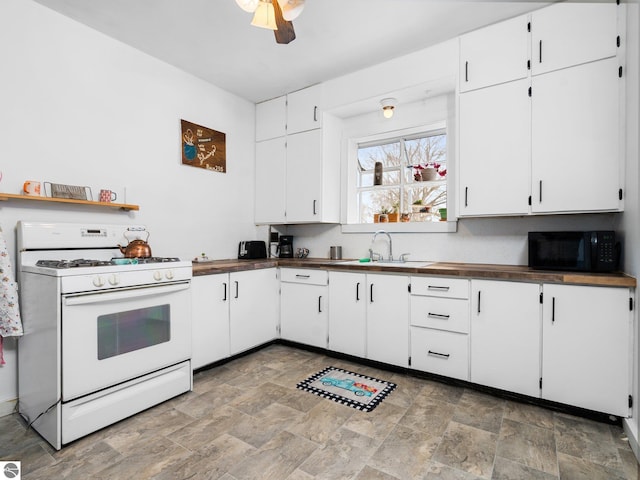 kitchen featuring white cabinetry, ceiling fan, gas range gas stove, and sink