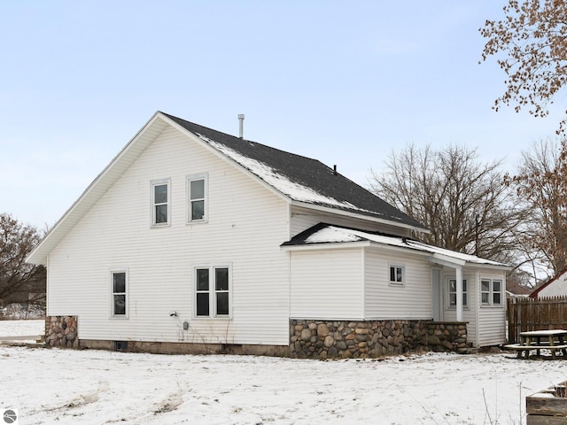 view of snow covered back of property