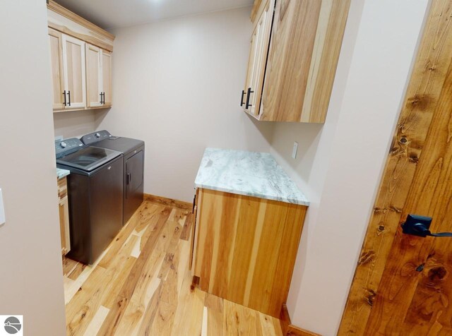 108 Rolling Oak Ln, Roscommon, MI 48653 - washroom with light wood finished floors, baseboards, washing machine and clothes dryer, and cabinet space