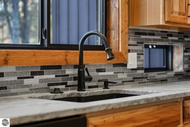 108 Rolling Oak Ln, Roscommon, MI 48653 - interior space featuring decorative backsplash, a sink, brown cabinets, and dishwasher
