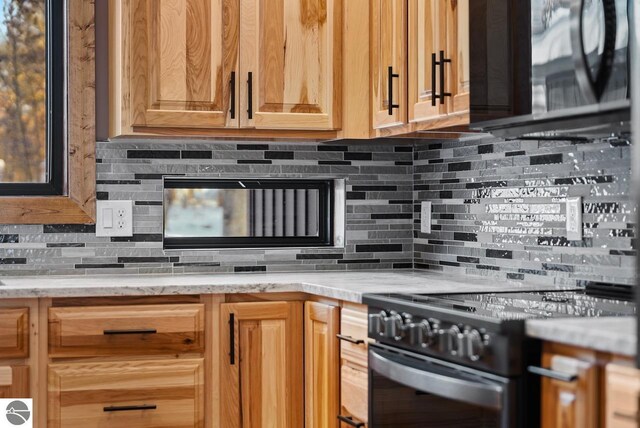 108 Rolling Oak Ln, Roscommon, MI 48653 - kitchen featuring black electric range, backsplash, and light stone counters