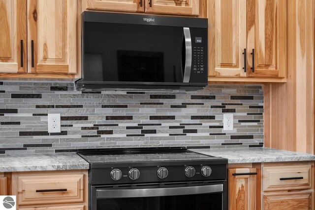108 Rolling Oak Ln, Roscommon, MI 48653 - kitchen featuring decorative backsplash, light stone countertops, light brown cabinets, and black / electric stove
