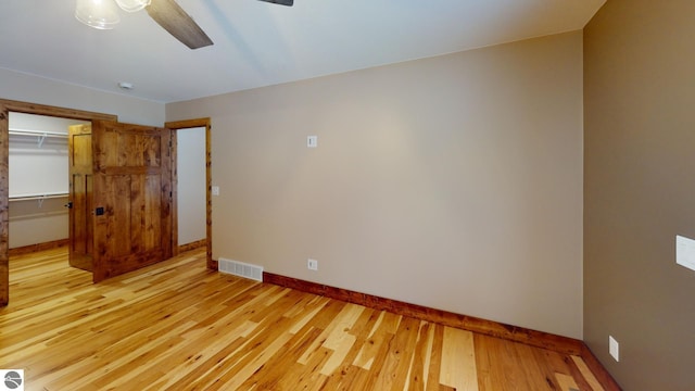 108 Rolling Oak Ln, Roscommon, MI 48653 - unfurnished bedroom with hardwood / wood-style floors, baseboards, ceiling fan, visible vents, and a closet