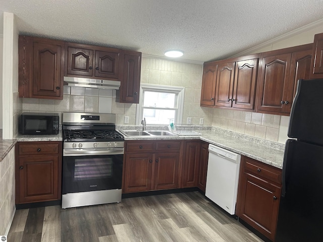 kitchen featuring a textured ceiling, vaulted ceiling, sink, black appliances, and dark hardwood / wood-style floors