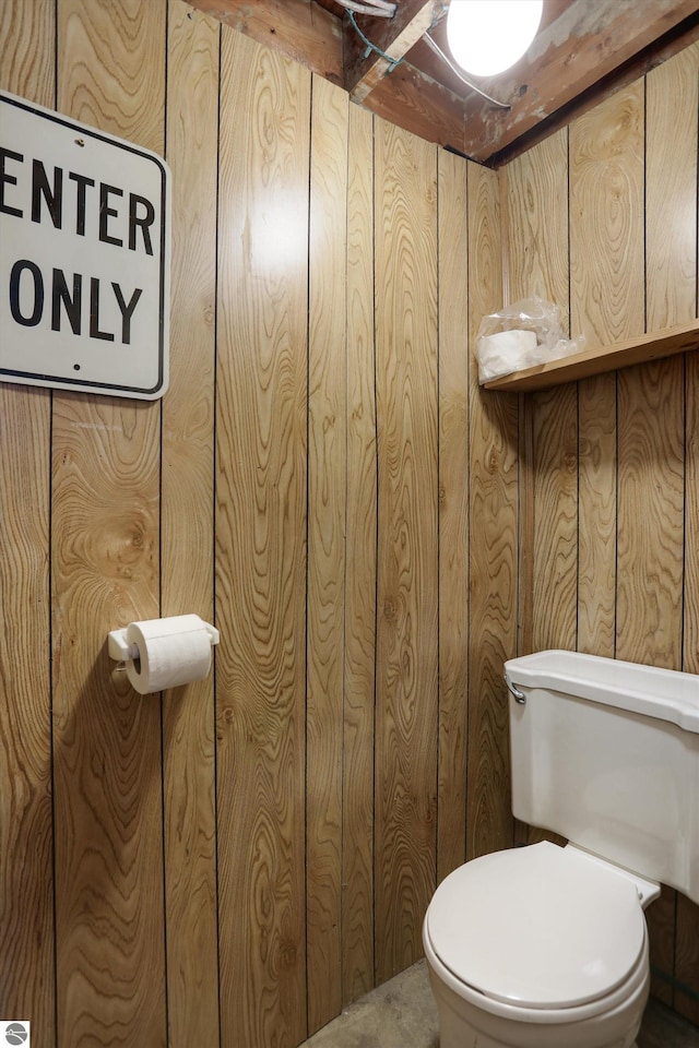 bathroom with wooden walls and toilet