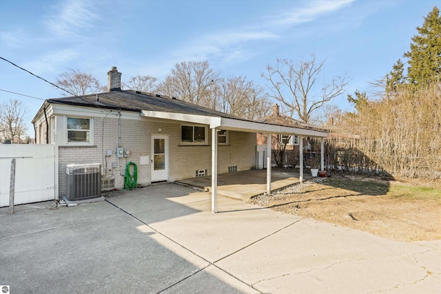 back of house featuring a carport and cooling unit