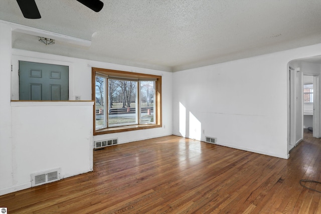 interior space with a textured ceiling, ceiling fan, and dark hardwood / wood-style floors