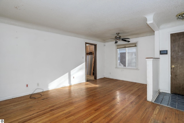 unfurnished living room with ceiling fan, wood-type flooring, and a textured ceiling