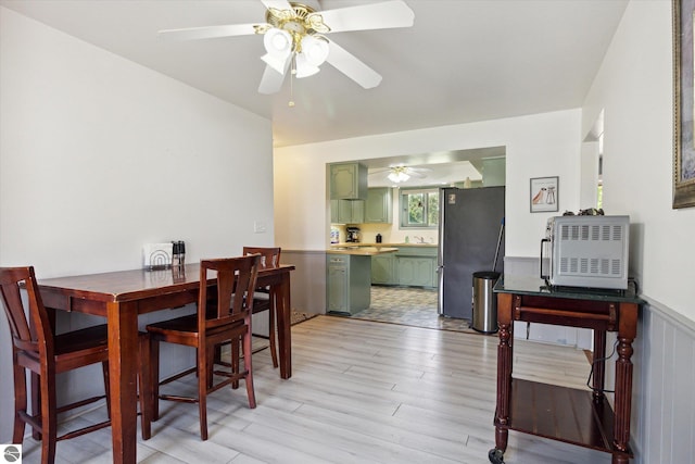 dining area featuring ceiling fan, light hardwood / wood-style flooring, and sink