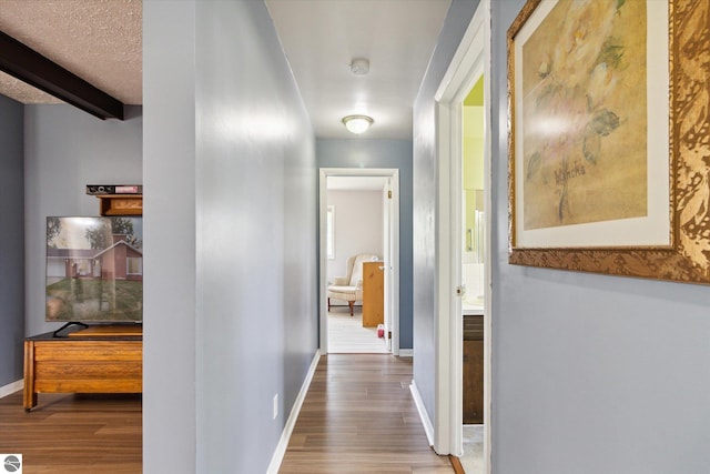 corridor with hardwood / wood-style flooring and a textured ceiling