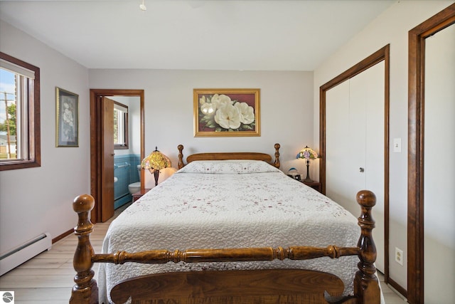 bedroom with light wood-type flooring, a closet, and a baseboard heating unit