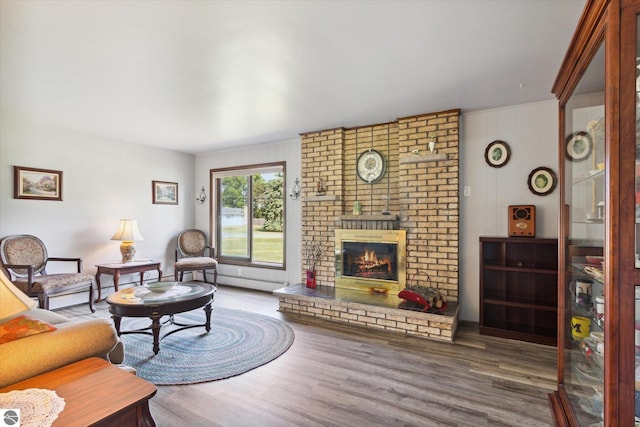 living room with wood-type flooring and a brick fireplace