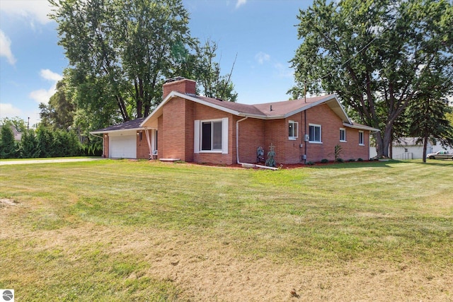 back of property featuring a garage and a yard