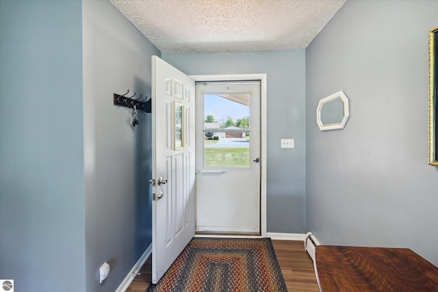 doorway to outside with hardwood / wood-style floors and a textured ceiling