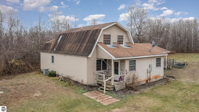 back of property with a lawn and cooling unit