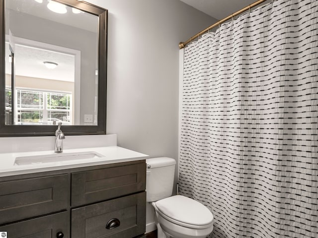 bathroom with a shower with shower curtain, vanity, toilet, and a textured ceiling