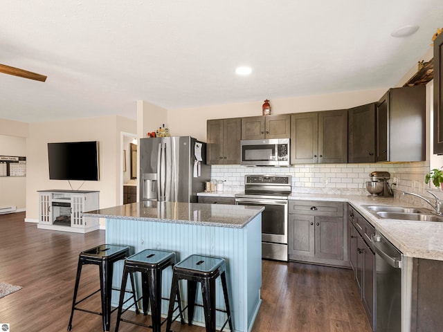 kitchen with a center island, sink, stainless steel appliances, and dark wood-type flooring