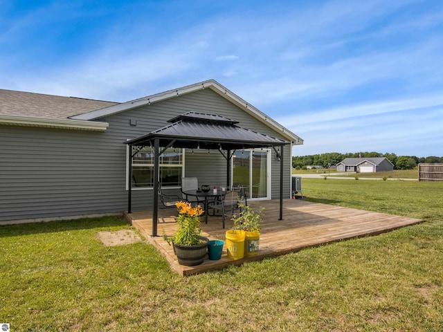 rear view of property with a gazebo, a yard, and a wooden deck