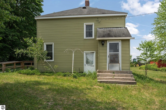 rear view of house featuring a yard