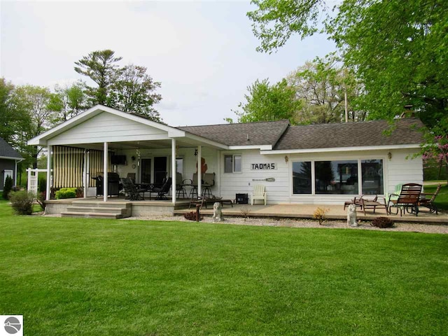 back of house featuring a yard and covered porch