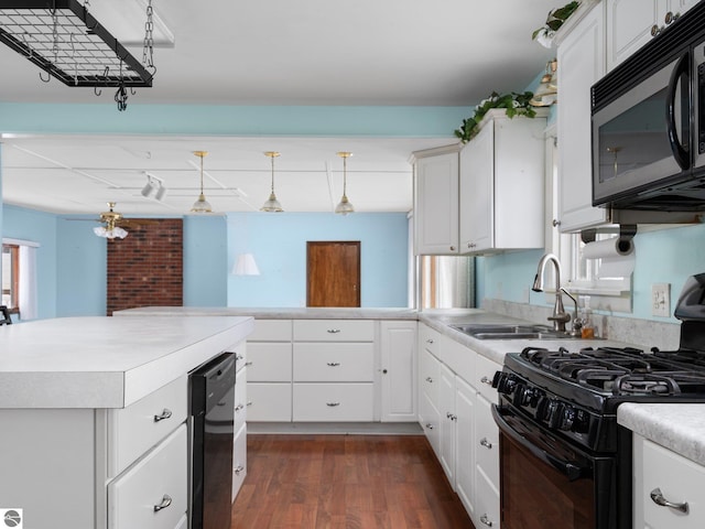 kitchen featuring black gas range oven, decorative light fixtures, white cabinetry, and dark wood-type flooring