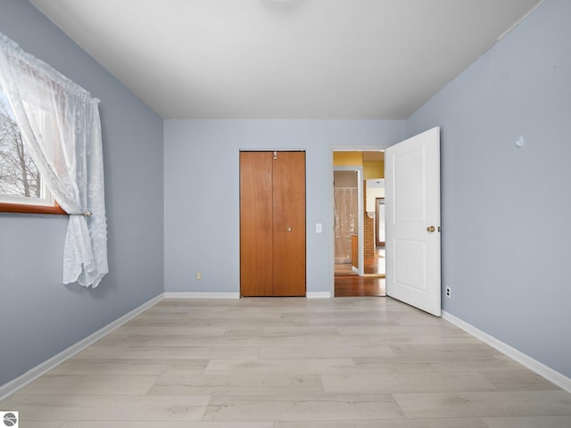 unfurnished bedroom featuring light wood-type flooring and a closet