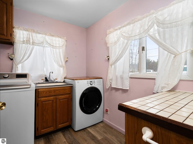 clothes washing area featuring cabinets, washer and clothes dryer, dark wood-type flooring, and sink