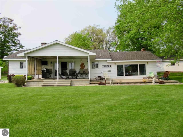 rear view of house featuring a lawn