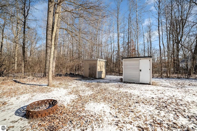 yard layered in snow featuring a storage unit