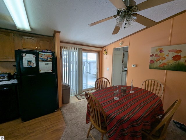 dining room with lofted ceiling, crown molding, ceiling fan, light wood-type flooring, and a textured ceiling