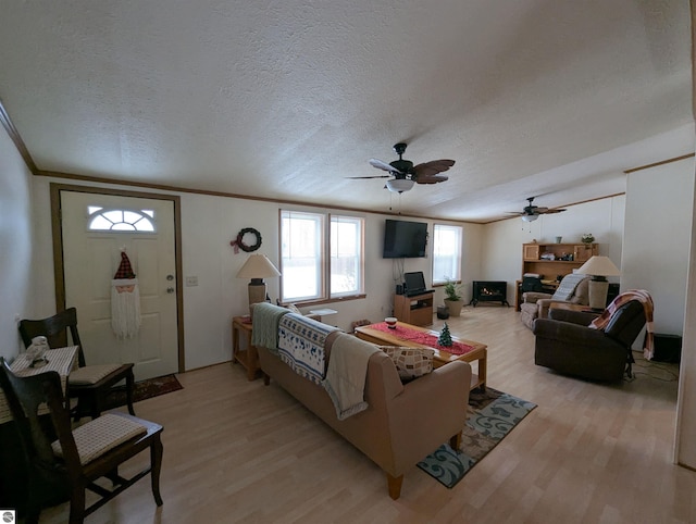 living room with a textured ceiling, light hardwood / wood-style floors, and ceiling fan