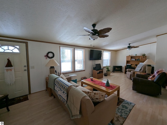 living room with ceiling fan, light hardwood / wood-style flooring, and a textured ceiling