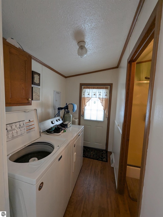 clothes washing area featuring cabinets, washing machine and dryer, crown molding, wood-type flooring, and a textured ceiling