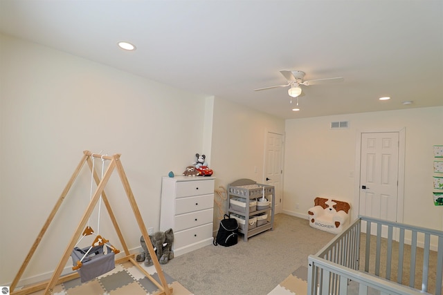 bedroom with carpet, a nursery area, and ceiling fan