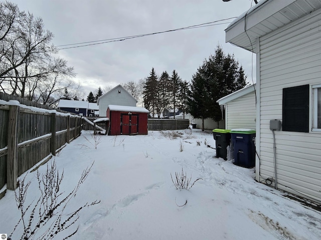 snowy yard featuring a shed